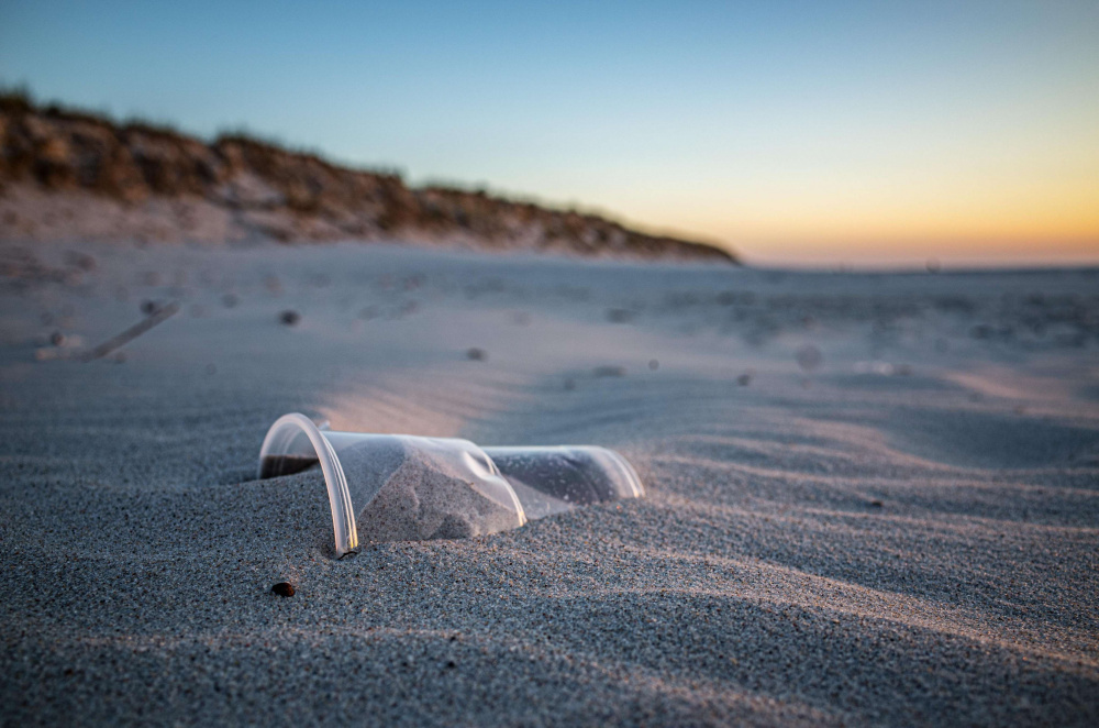Déchet d'un gobelet en plastique sur une plage